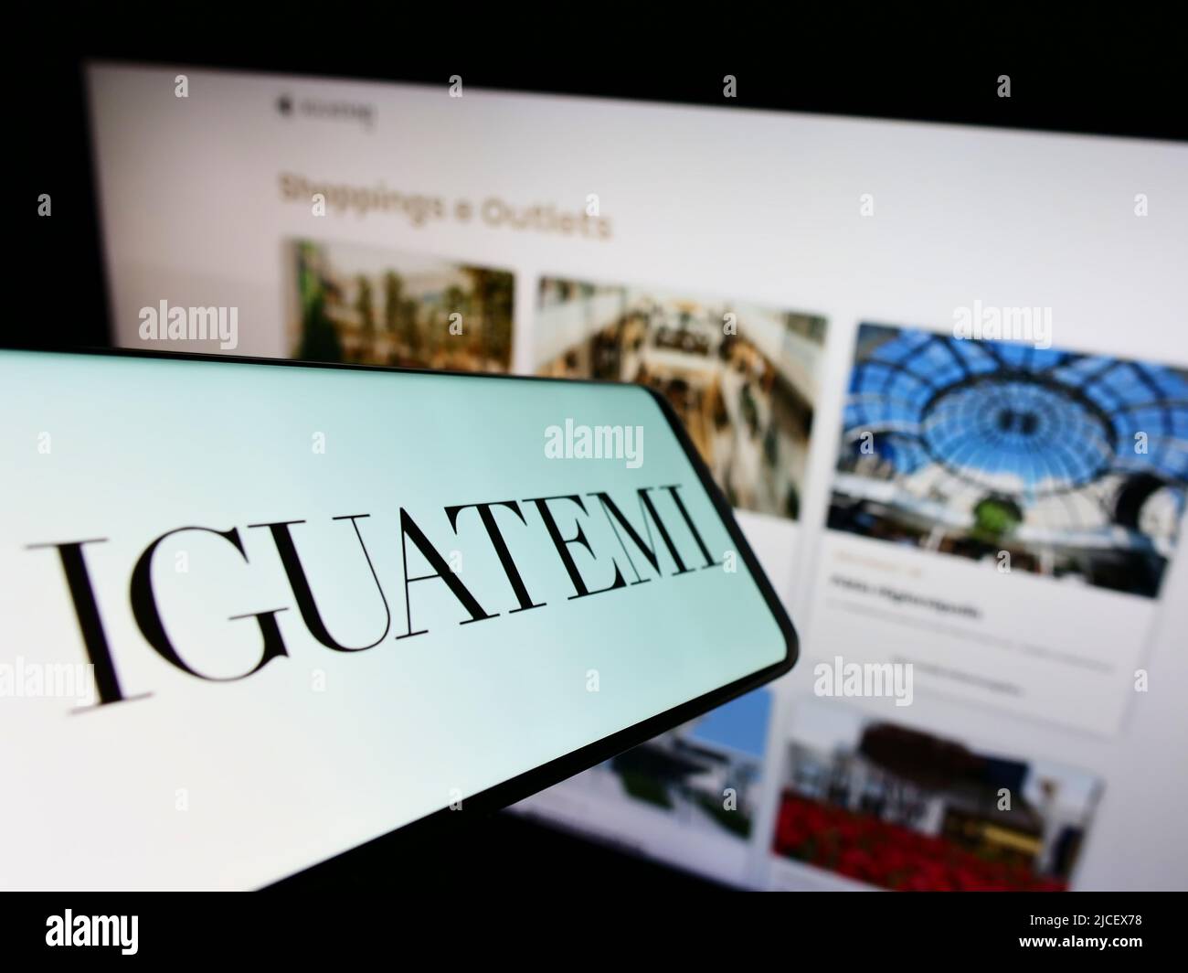Smartphone con logo della società Iguatemi Empresa de Shopping Centers S.A. sullo schermo di fronte al sito web. Concentratevi sul centro-destra del display del telefono. Foto Stock