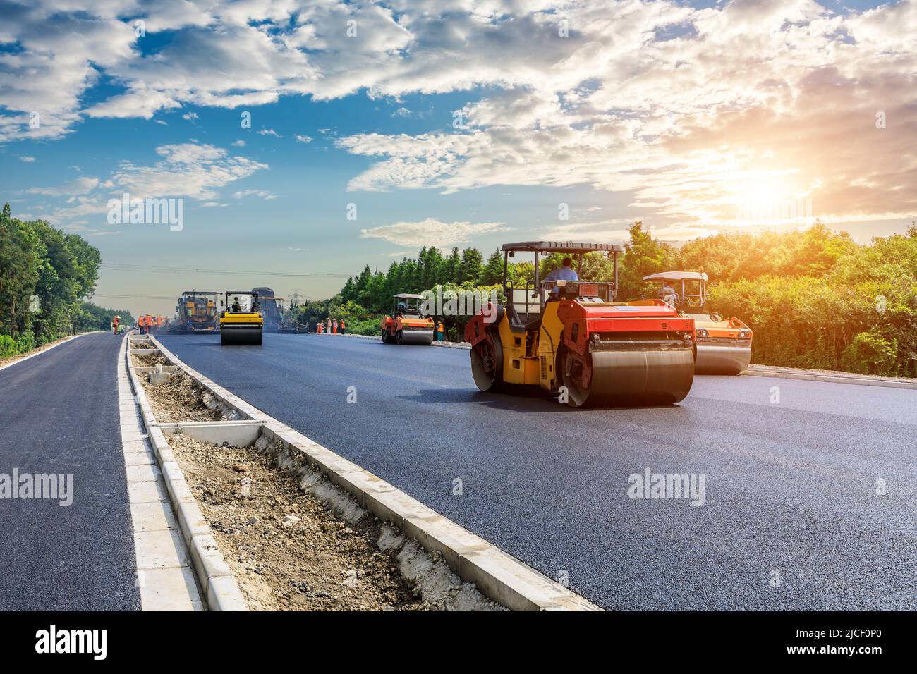 Il cantiere sta ponendo nuove pavimentazioni in asfalto, operai edili e macchinari per la costruzione di strade. Cantiere autostradale. Foto Stock