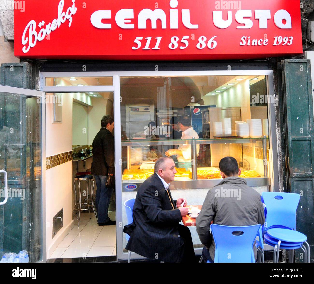 Gli uomini turchi gustano la loro colazione al Cemil usta börekçi (negozio Bureq) a Fatih, Istanbul, Turchia. Foto Stock