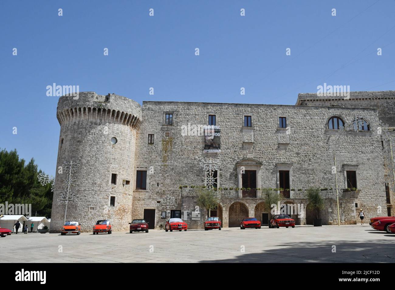 Raduno di auto sportive di fronte al castello di Conversano, un centro storico del sud Italia. Foto Stock