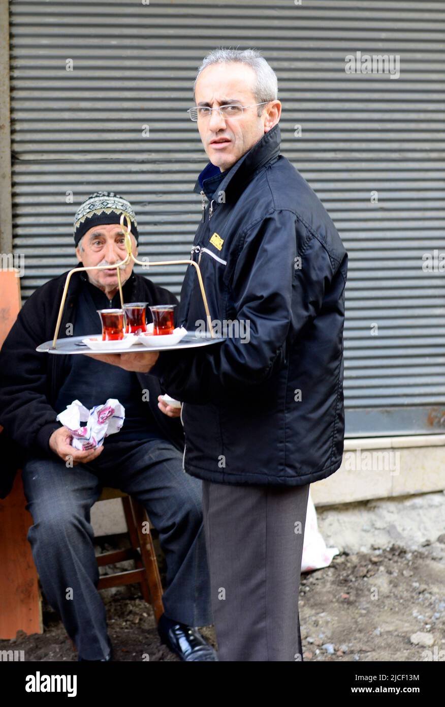 Un uomo turco che serve il tè in un piccolo negozio di tè a Istanbul, Turchia. Foto Stock