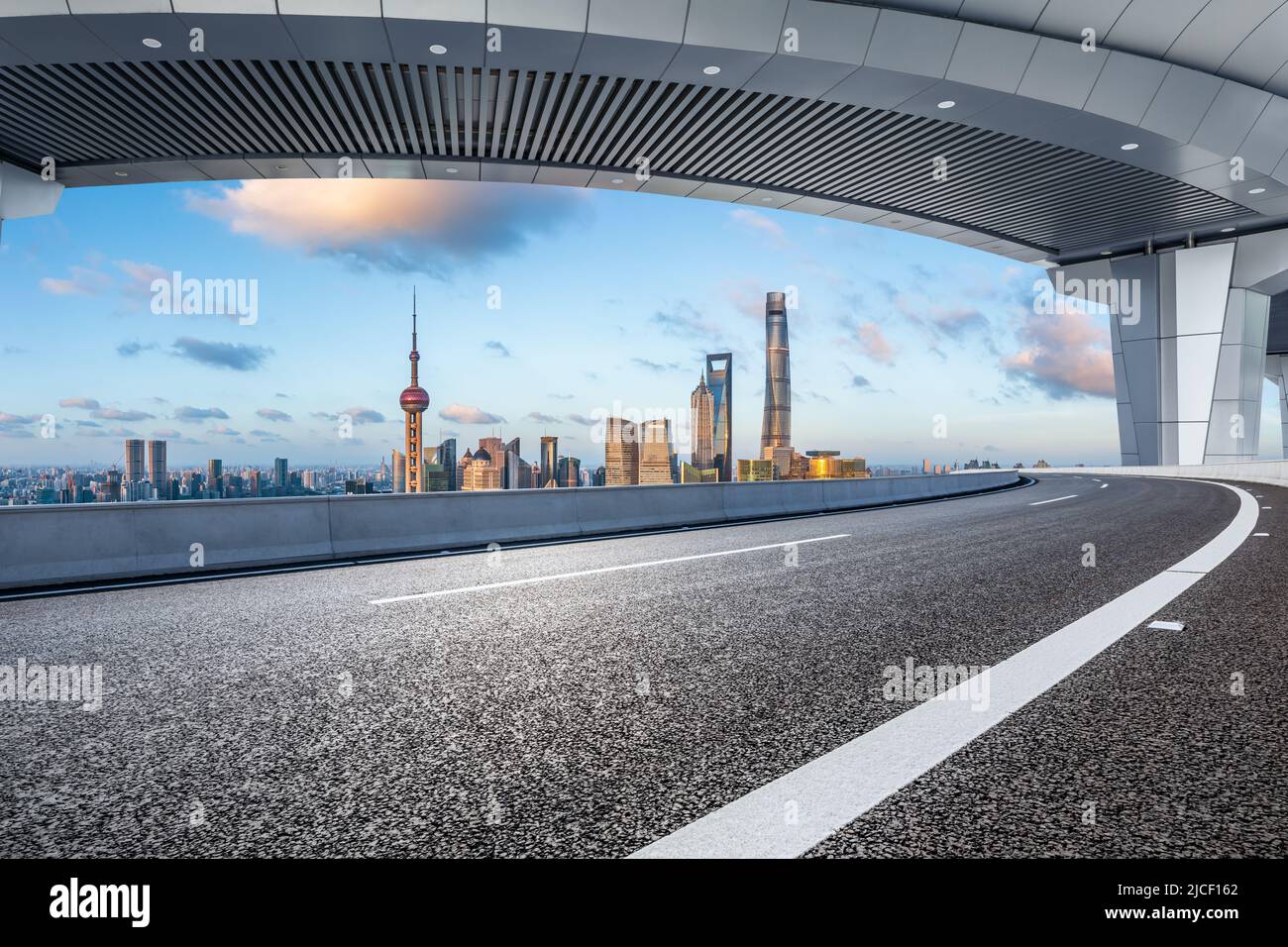 Asfalto autostrada e skyline della città con edifici moderni a Shanghai al tramonto, Cina. Foto Stock
