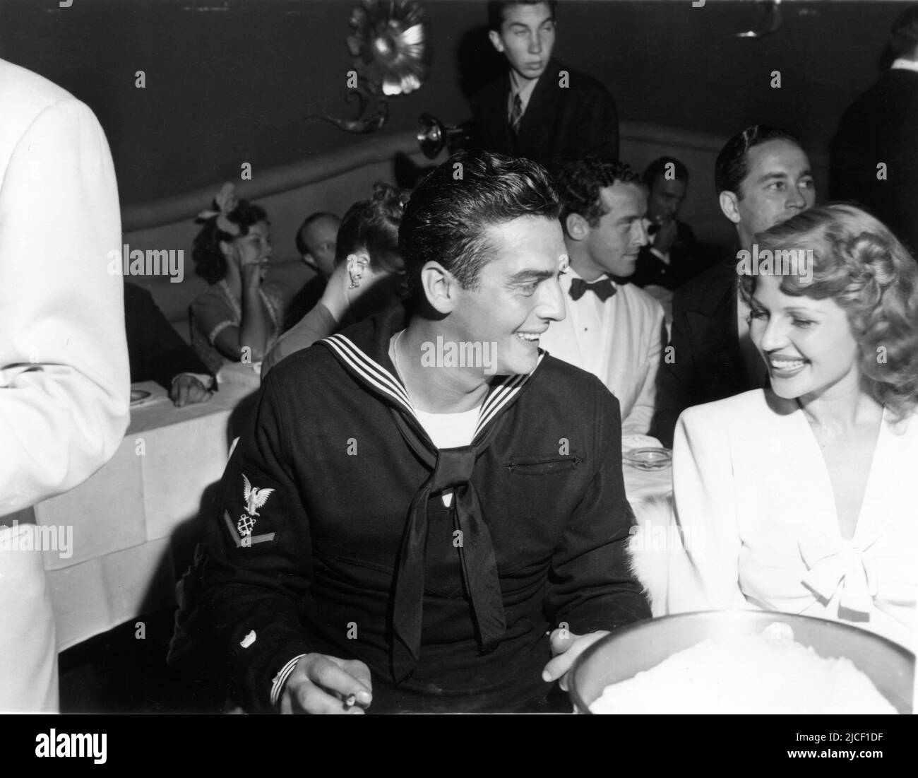 VICTOR MATURO nella sua uniforme della Guardia Costiera degli Stati Uniti con la ragazza RITA HAYWORTH 1942 nightclub candid Foto Stock