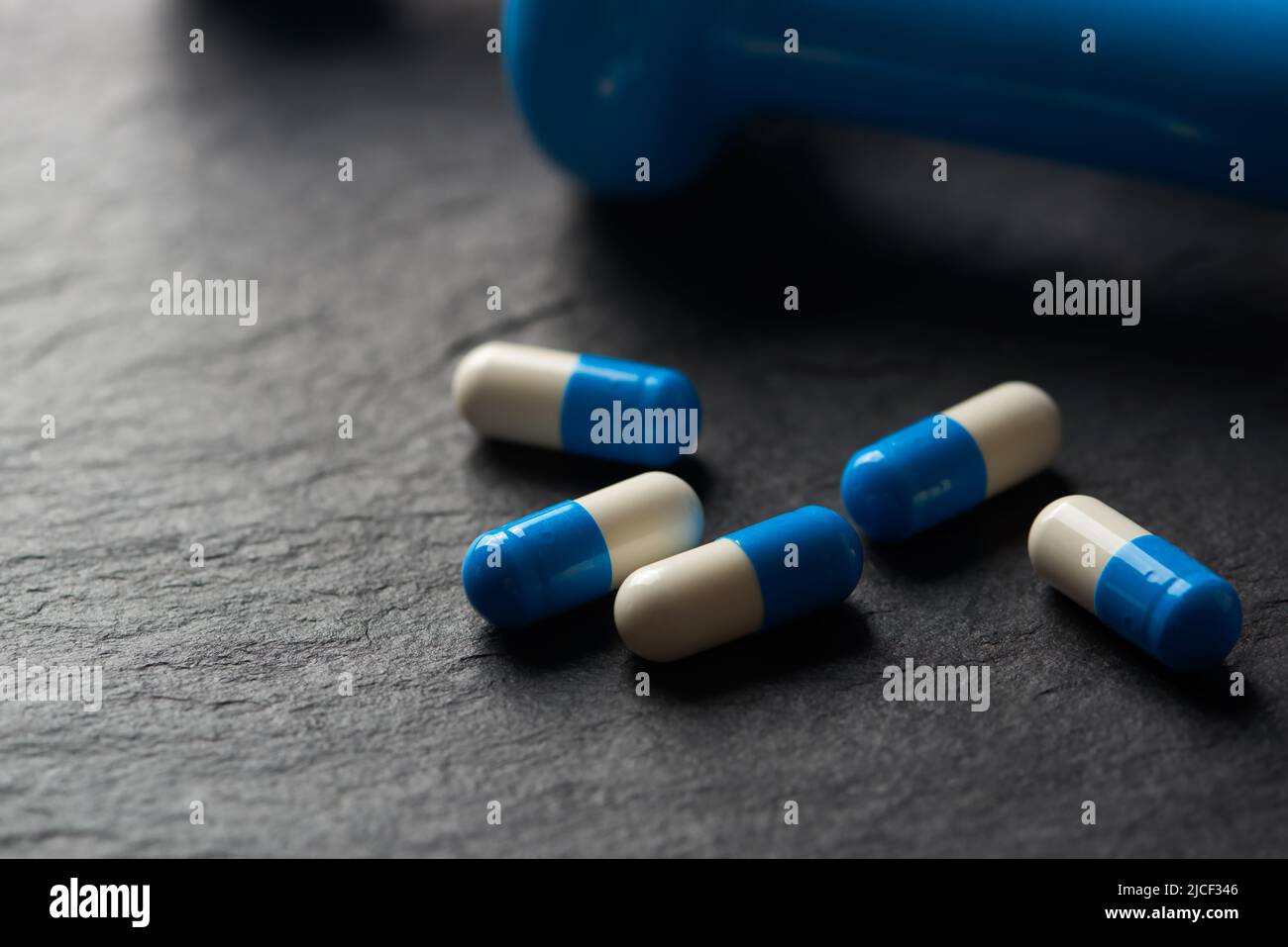 Supplementi sportivi (creatina capsule) su sfondo di pietra scura. Primo piano. Spazio di copia. Foto Stock