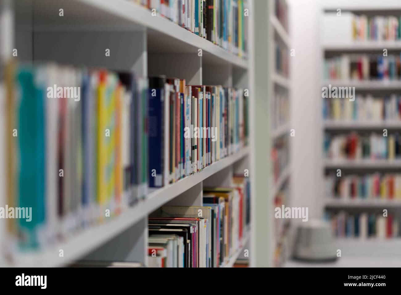 Stoccarda, Germania - Nov 16, 2021: Vista laterale su un libro in uno scaffale in biblioteca pubblica. Sfondo chiaro e sfocato. Simbolo per conoscenza e lettura. Foto Stock