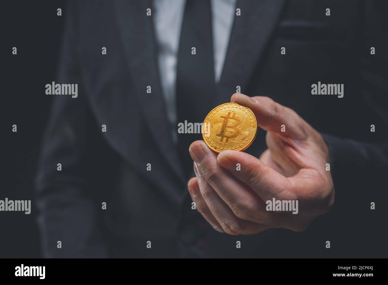 Datore di lavoro che offre pagamento salariale con criptovaluta Bitcoin, primo piano di mano con cripto moneta, fuoco selettivo Foto Stock