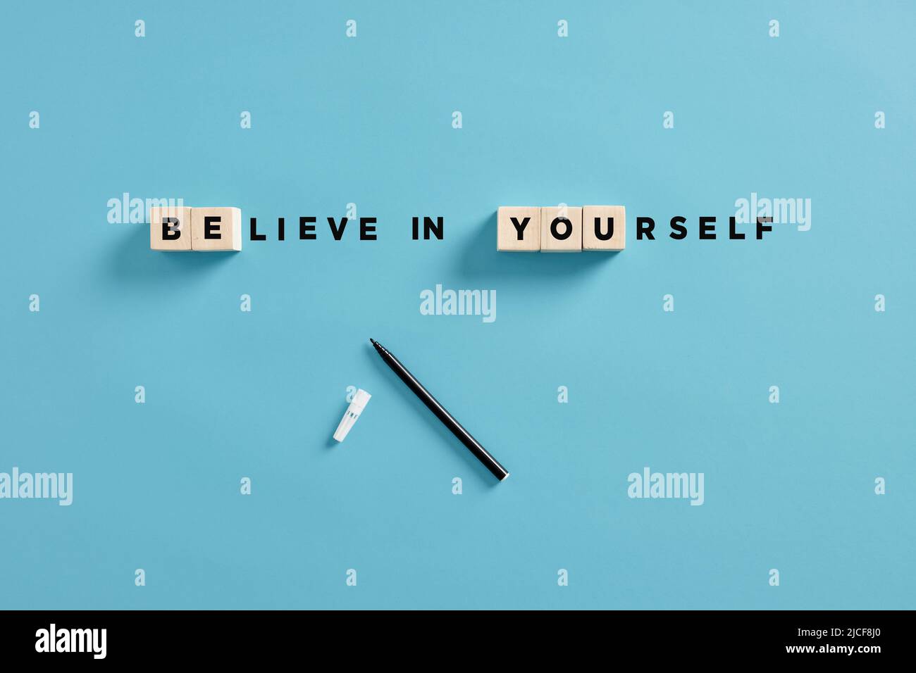 Il messaggio motivazionale credete in voi stessi con i cubi di legno. Fiducia in se stessi, coraggio, incoraggiamento e concetto di fiducia personale. Foto Stock