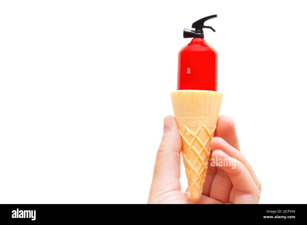 Estintore giocattolo all'interno di un cono di cialda per gelato in mano isolato su sfondo bianco. Rinfrescarsi durante l'estate calda. Foto Stock