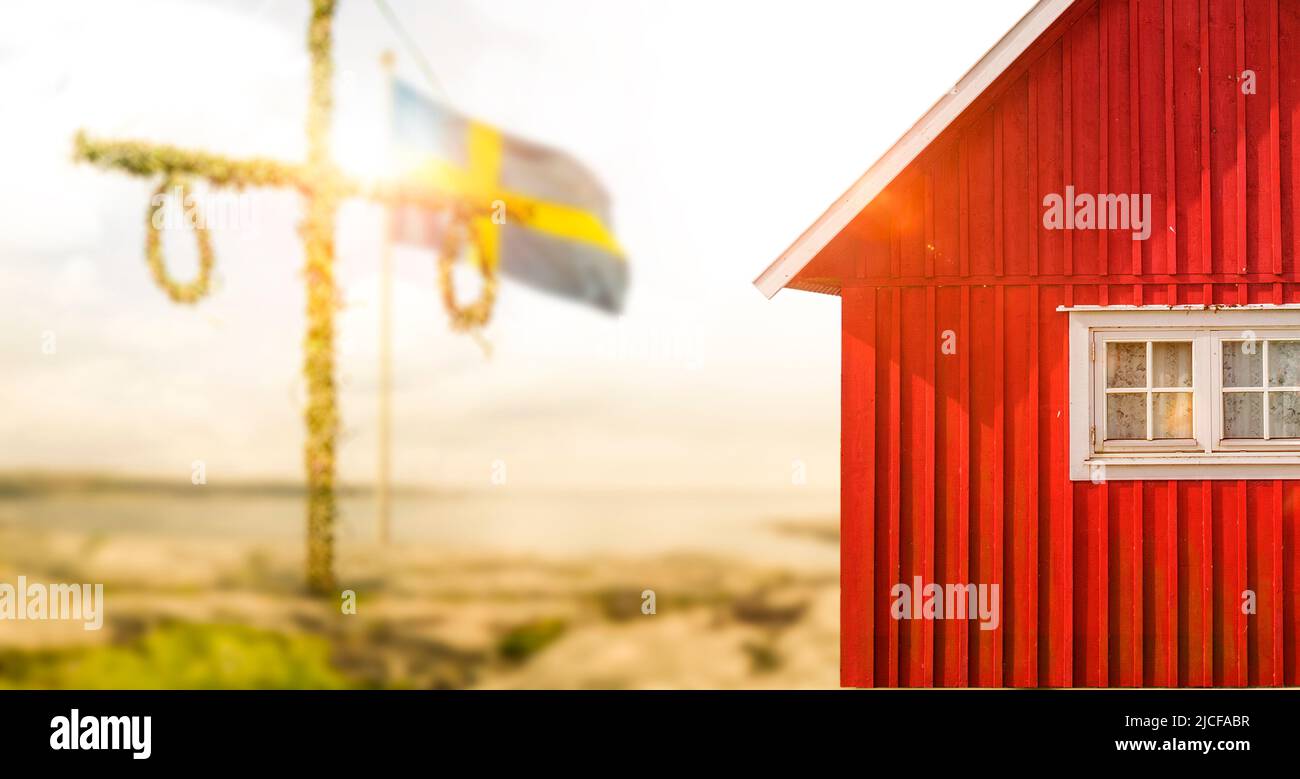 Casa svedese rossa con bandiera svedese con luce solare Foto Stock