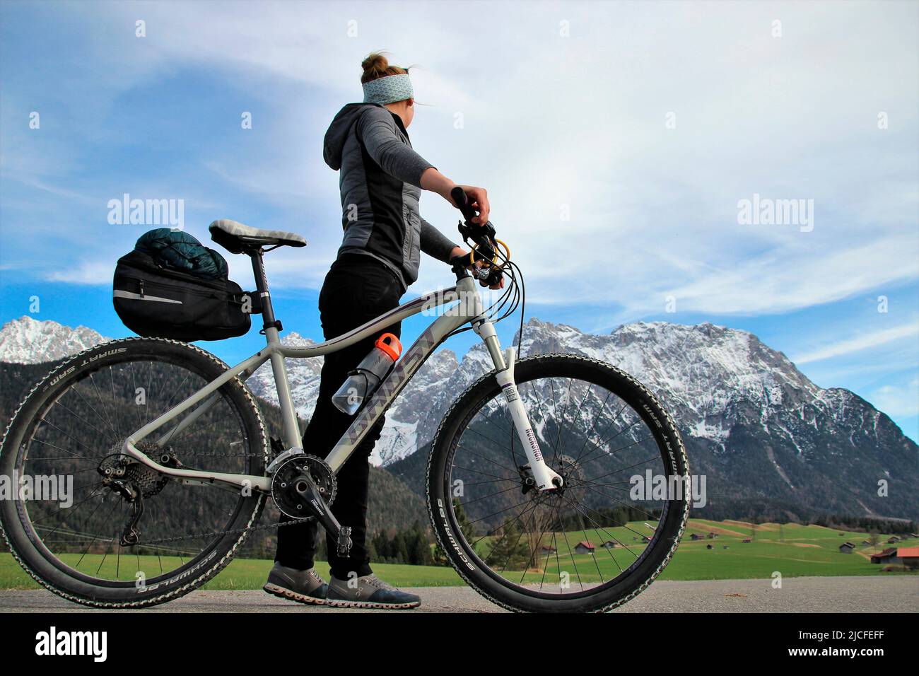 Tour in mountain bike nei prati umpback vicino a Mittenwald, Germania, Baviera, alta Baviera, valle dell'Isar, Strada, sentiero, bicicletta, montagne Karwendel, cielo blu Foto Stock
