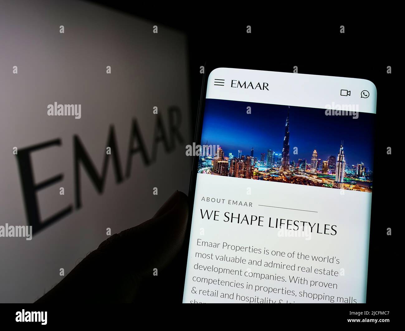 Persona che detiene il cellulare con sito web della società immobiliare Emaar Proprietà PJSC sullo schermo di fronte al logo. Concentrarsi sul centro del display del telefono. Foto Stock