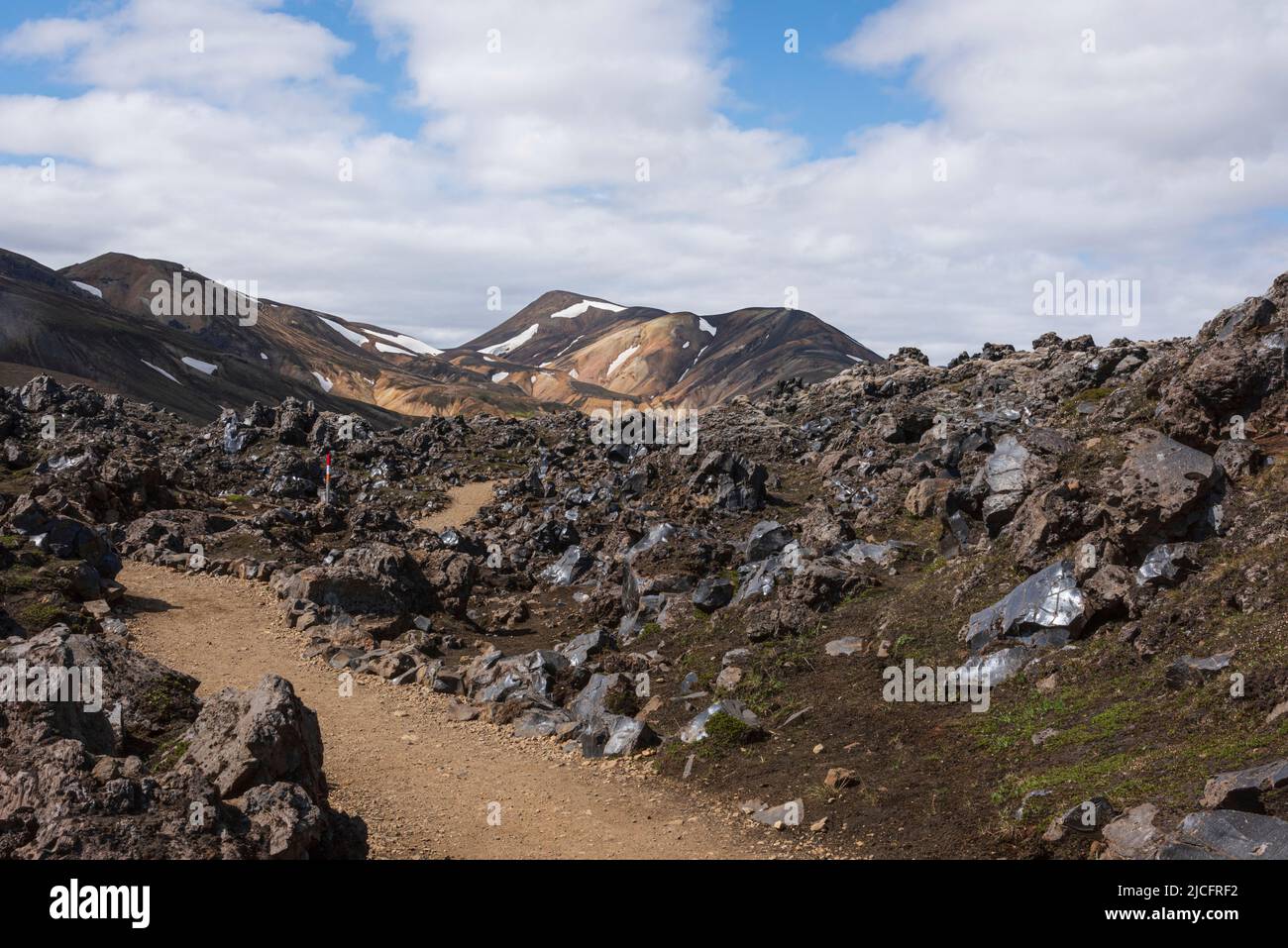 Il sentiero escursionistico di Laugavegur è il più famoso tour di trekking di più giorni in Islanda. Paesaggio girato dalla zona intorno a Landmannalaugar, punto di partenza del sentiero escursionistico a lunga distanza negli altopiani dell'Islanda. Percorso attraverso un campo di lava. Foto Stock