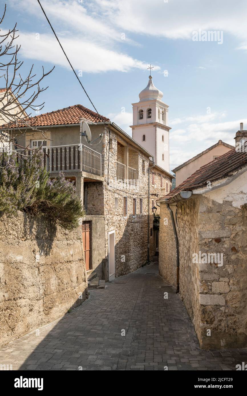 Vicolo con case tipiche e torre della chiesa nella piccola città di Skradin, contea di Sibenik-Knin, Dalmazia Centrale, Croazia, Europa Foto Stock