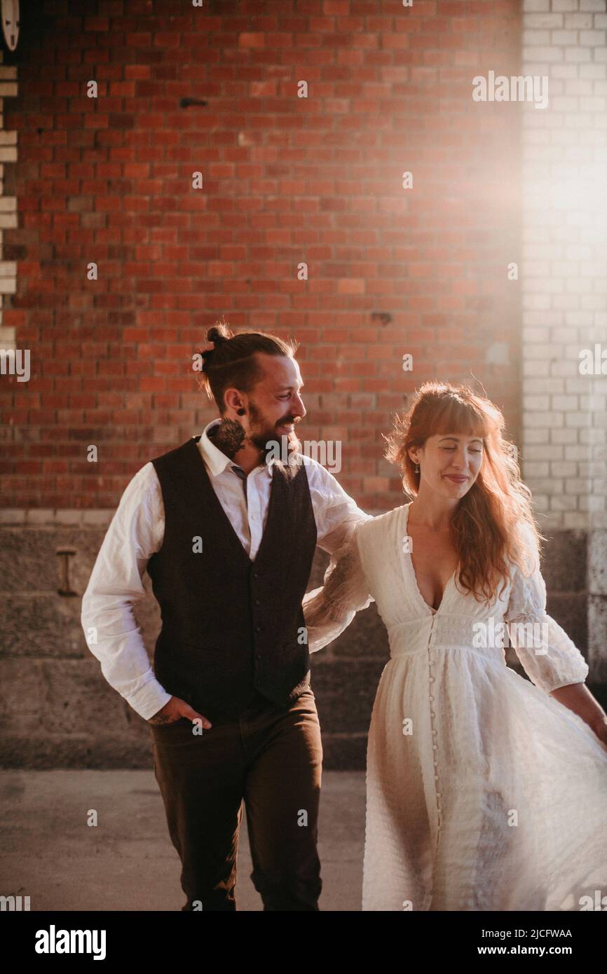 Giovane coppia innamorata di fronte al muro di mattoni Foto Stock