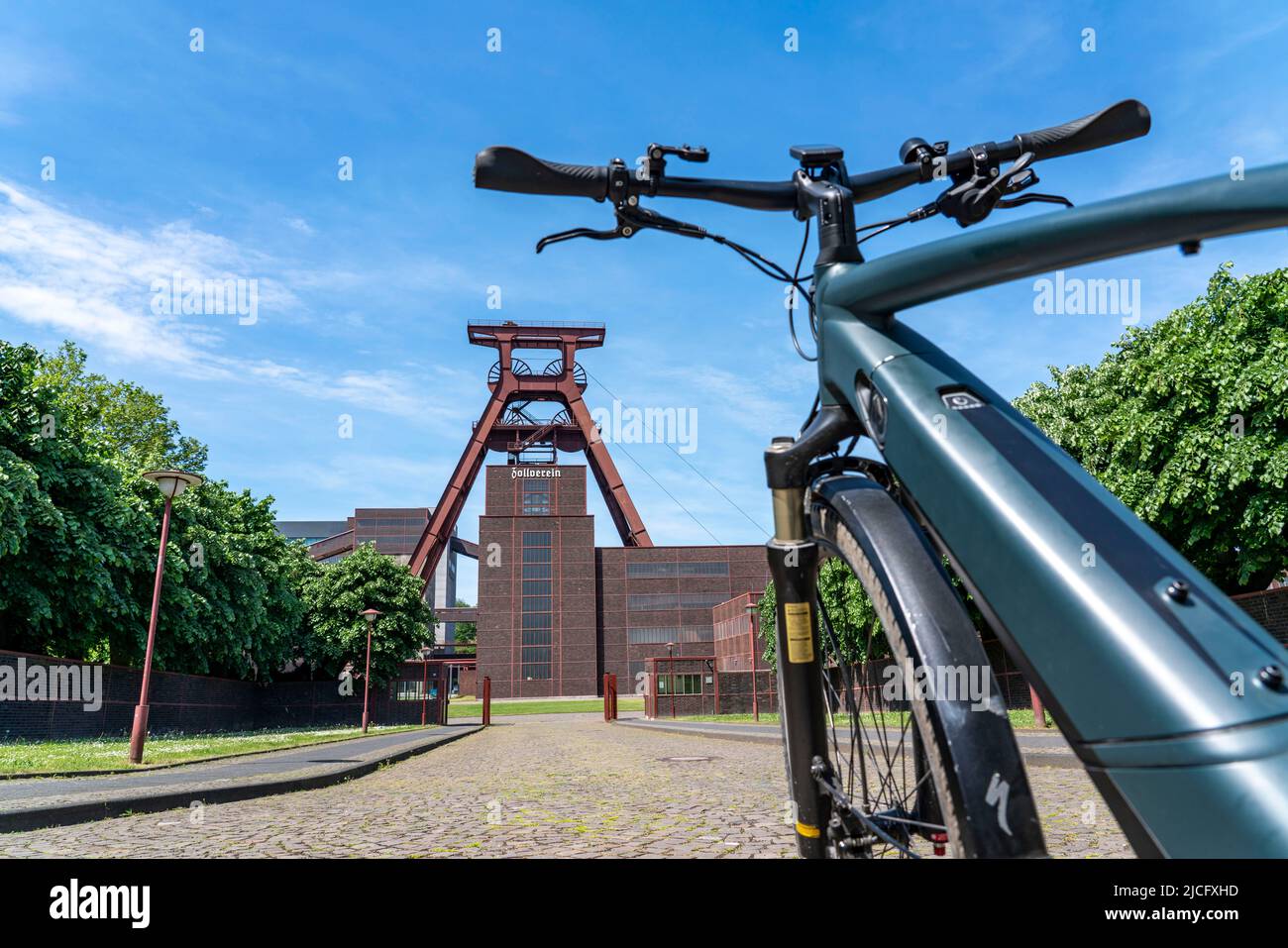 In bicicletta nella zona della Ruhr, in bicicletta, in e-bike, presso la miniera di carbone di Zollverein Sito Patrimonio Mondiale dell'Umanità, albero a doppio traliccio XII, Essen, NRW, Germania, Foto Stock