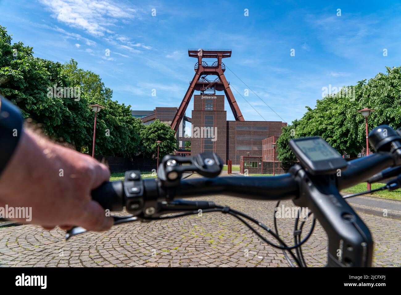 In bicicletta nella zona della Ruhr, in bicicletta, in e-bike, presso la miniera di carbone di Zollverein Sito Patrimonio Mondiale dell'Umanità, albero a doppio traliccio XII, Essen, NRW, Germania, Foto Stock