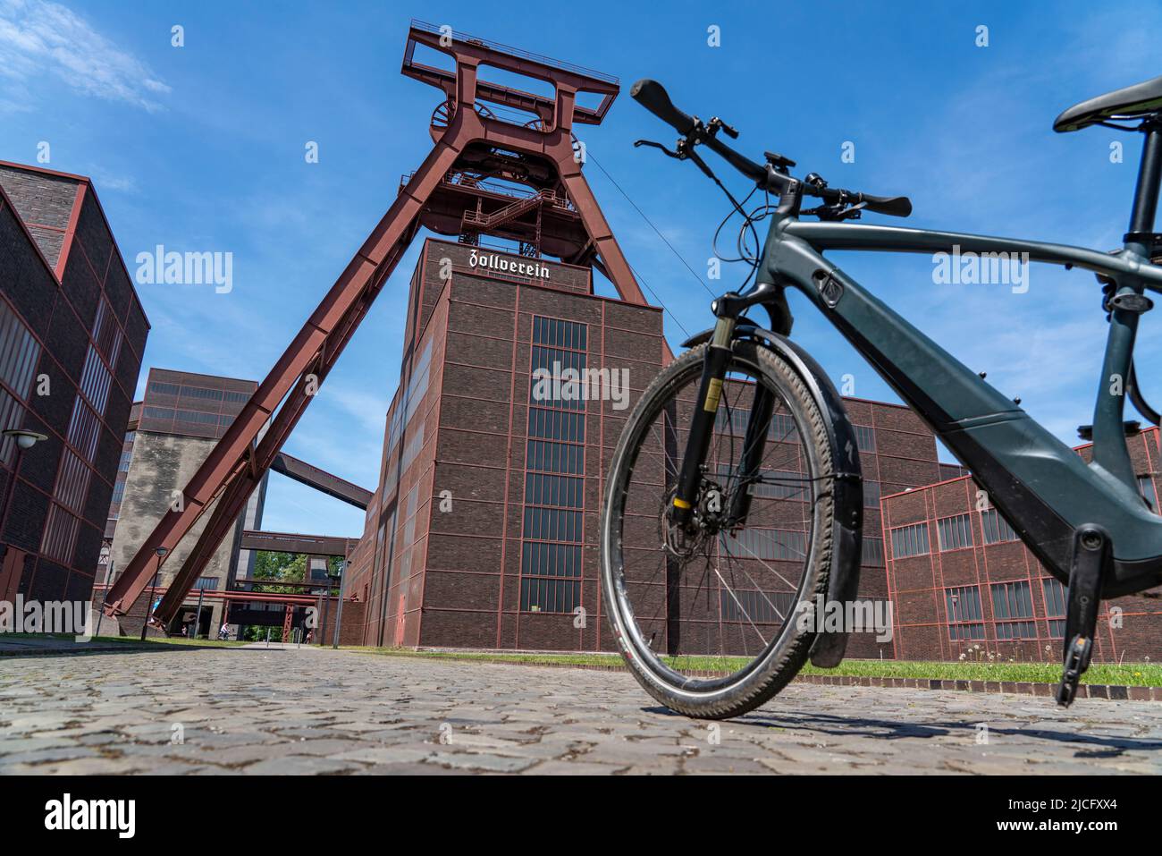 In bicicletta nella zona della Ruhr, in bicicletta, in e-bike, presso la miniera di carbone di Zollverein Sito Patrimonio Mondiale dell'Umanità, albero a doppio traliccio XII, Essen, NRW, Germania, Foto Stock