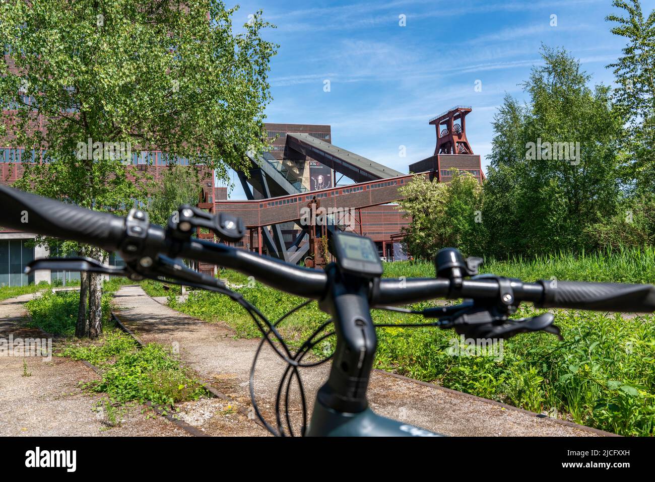 In bicicletta nella zona della Ruhr, in bicicletta, in e-bike, presso la miniera di carbone di Zollverein Sito Patrimonio Mondiale dell'Umanità, albero a doppio traliccio XII, Essen, NRW, Germania, Foto Stock