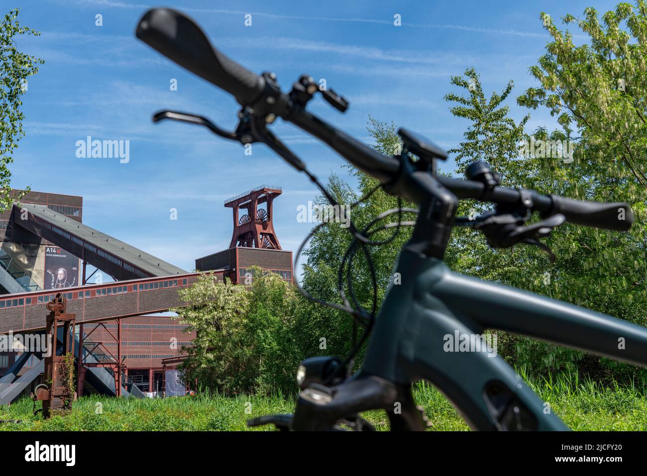 In bicicletta nella zona della Ruhr, in bicicletta, in e-bike, presso la miniera di carbone di Zollverein Sito Patrimonio Mondiale dell'Umanità, albero a doppio traliccio XII, Essen, NRW, Germania, Foto Stock