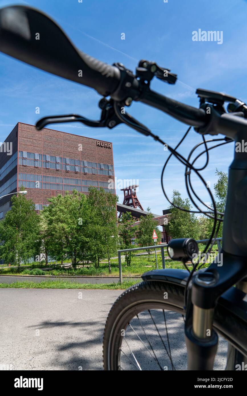 In bicicletta nella zona della Ruhr, in bicicletta, in e-bike, presso la miniera di carbone di Zollverein Sito Patrimonio Mondiale dell'Umanità, albero a doppio traliccio XII, Essen, NRW, Germania, Foto Stock