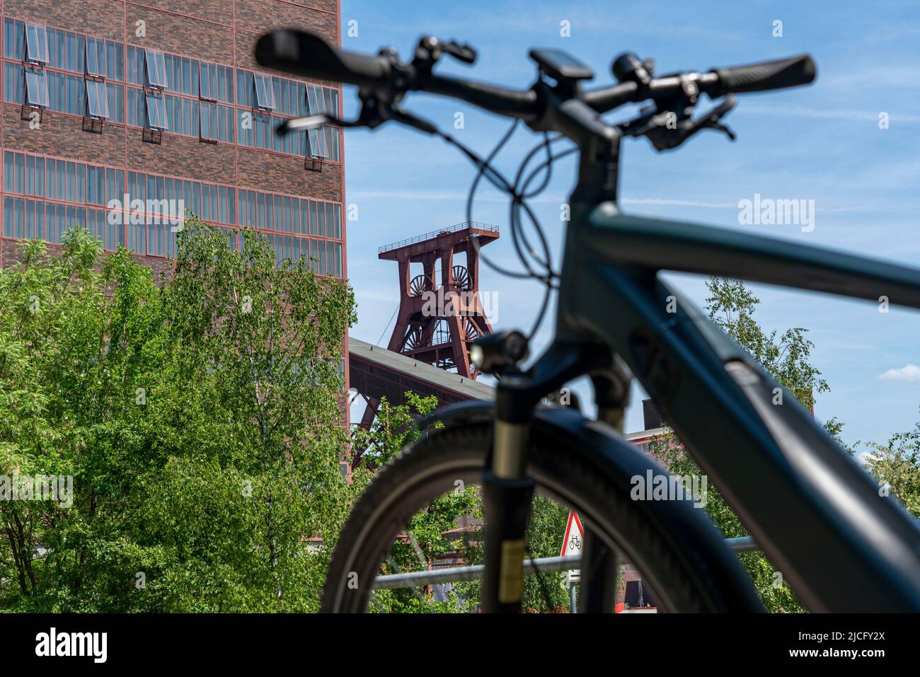 In bicicletta nella zona della Ruhr, in bicicletta, in e-bike, presso la miniera di carbone di Zollverein Sito Patrimonio Mondiale dell'Umanità, albero a doppio traliccio XII, Essen, NRW, Germania, Foto Stock