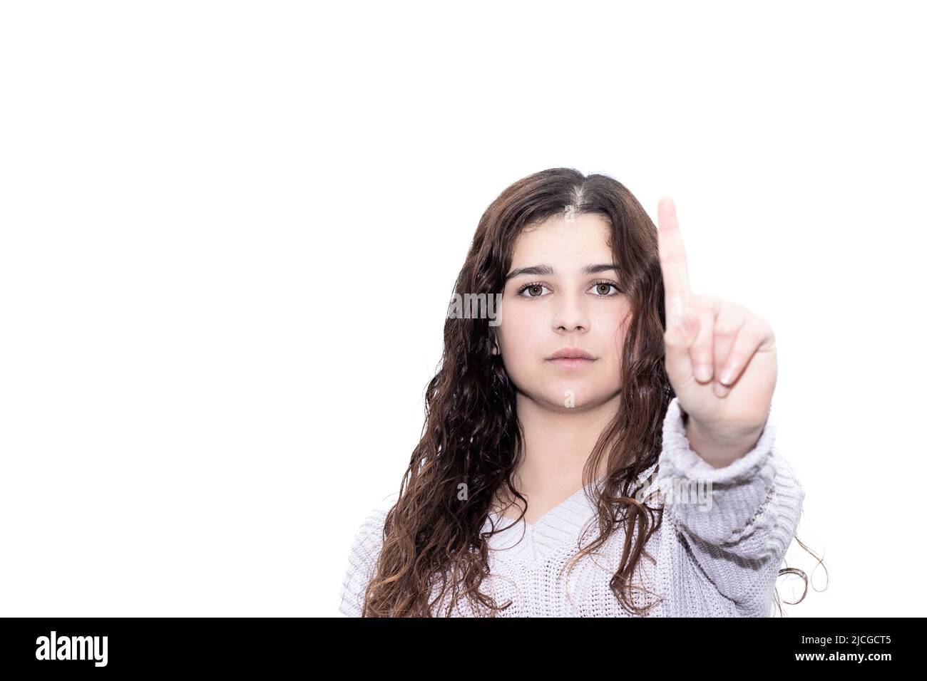 donna brunetta che alza un dito come un segno che è la migliore su sfondo bianco Foto Stock