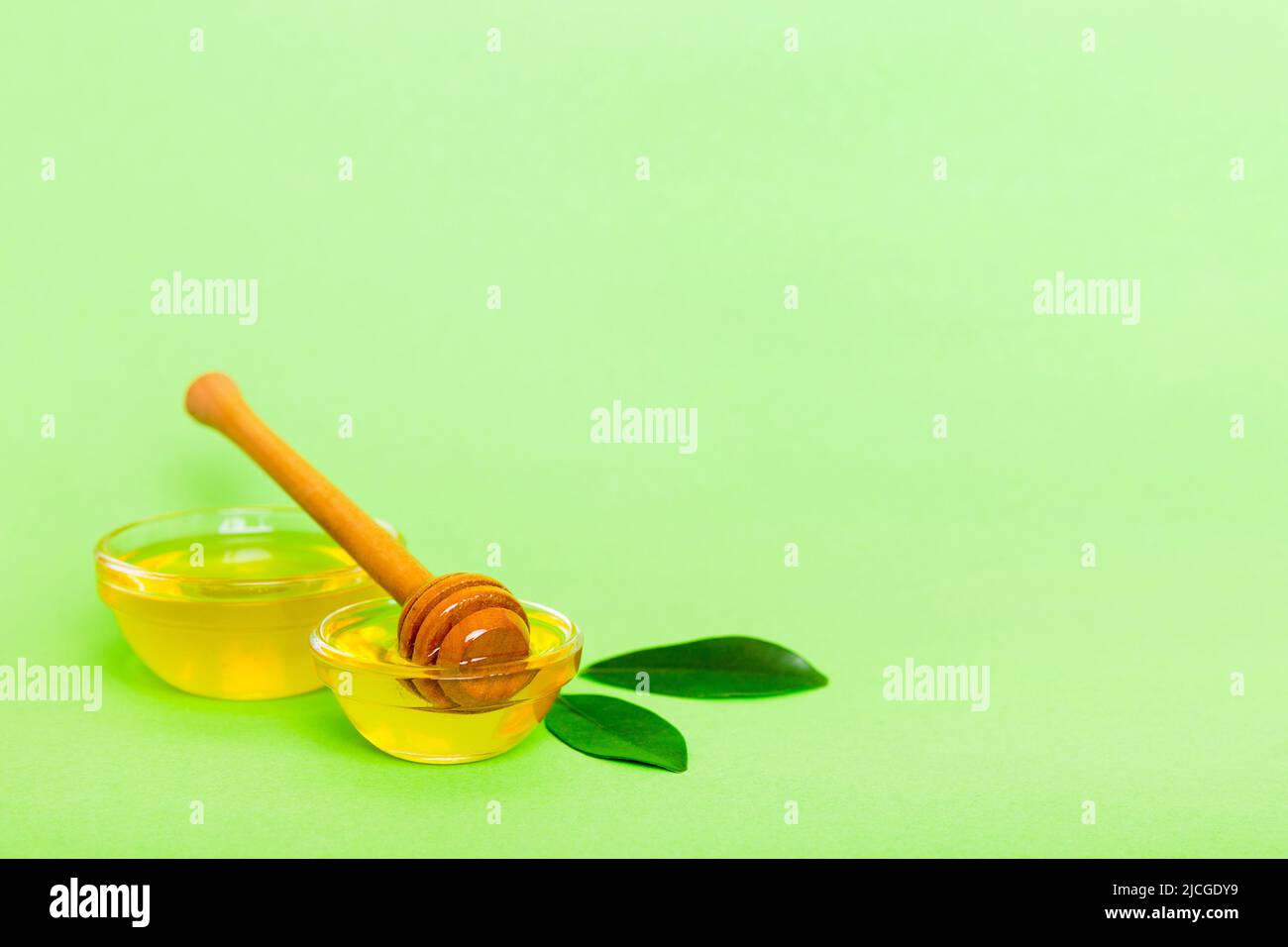 Miele in vaso con foglie e cucchiaia di miele su sfondo colorato vista dall'alto con testo di copia. Foto Stock