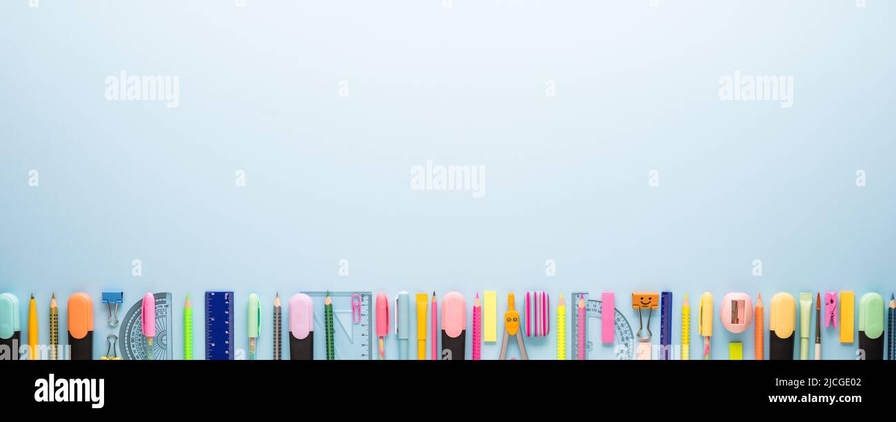 Cancelleria scolastica su sfondo blu. Modello fotografico creativo di ritorno a scuola con spazio di copia Foto Stock