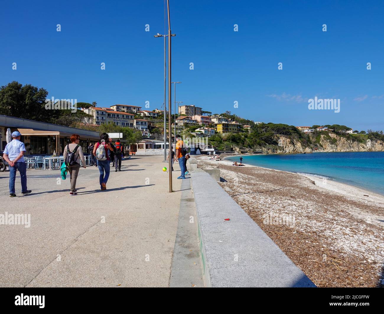 Persone che camminano lungo la Spiaggia delle Ghiaie, la spiaggia pubblica, Portoferraio, Elba, Provincia di Livorno, Italia. Foto Stock
