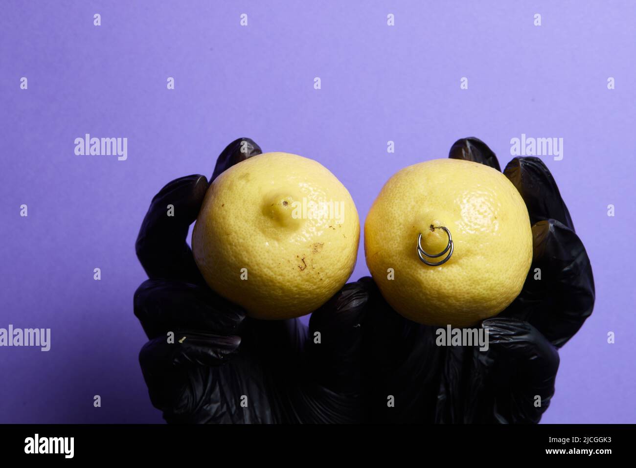 piercing orecchini in un limone su sfondo Foto Stock