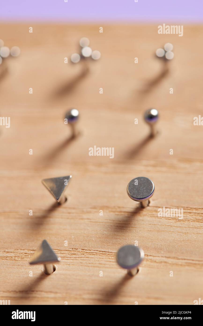 Bella gioielli piercing su display in legno. Scatto macro. Messa a fuoco selettiva Foto Stock