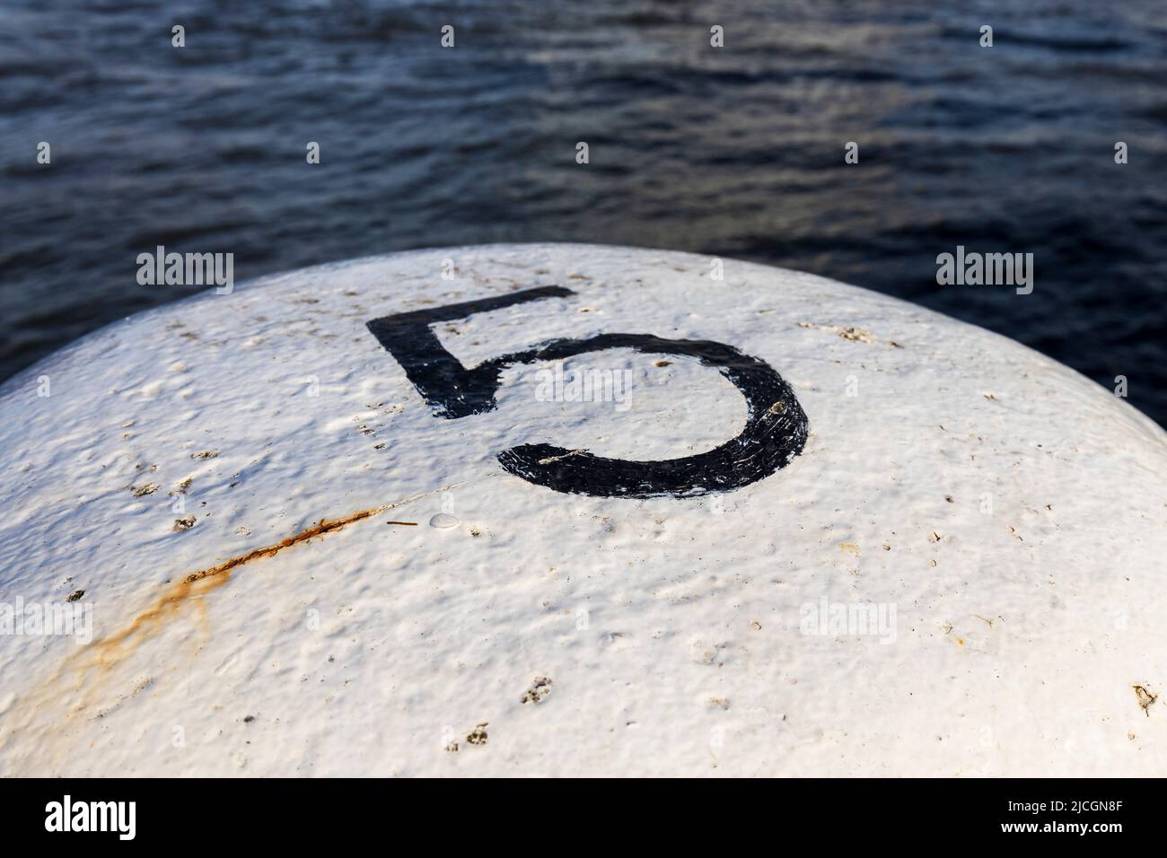 Il numero cinque dipinto in nero su un paletto bianco Foto Stock