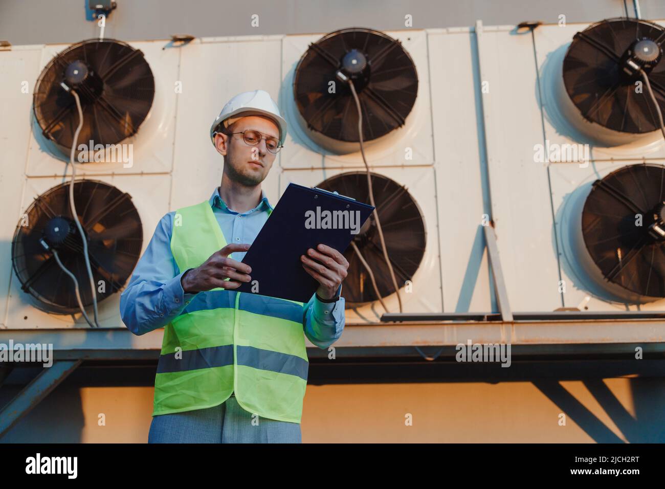 Tecnico hvac addetto alla manutenzione per l'ispezione uniforme del sistema di refrigerazione industriale Foto Stock