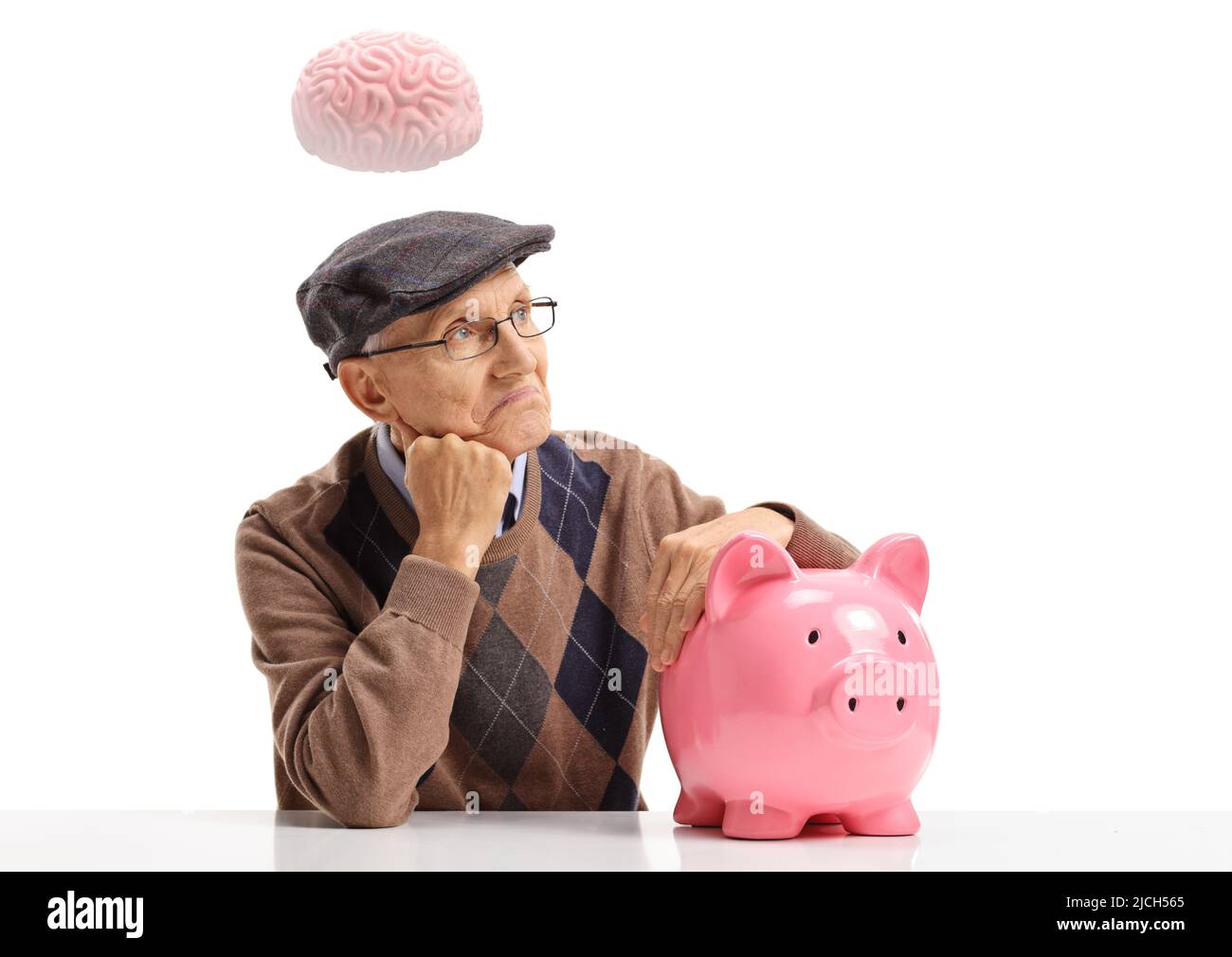 Uomo anziano pensivo con un piggybank che pensa con un cervello sopra la sua testa isolato su sfondo bianco Foto Stock
