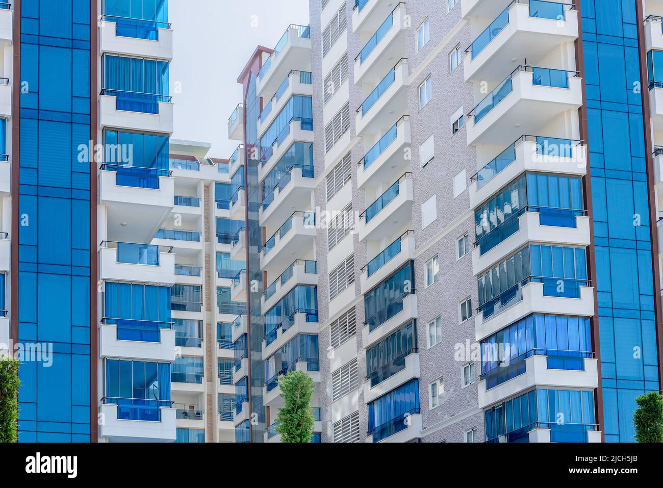 Vista astratta di un complesso residenziale multi-familiare di condomini con finestre balconi dipinti in blu e bianco. Architettura di sfondo. Foto Stock