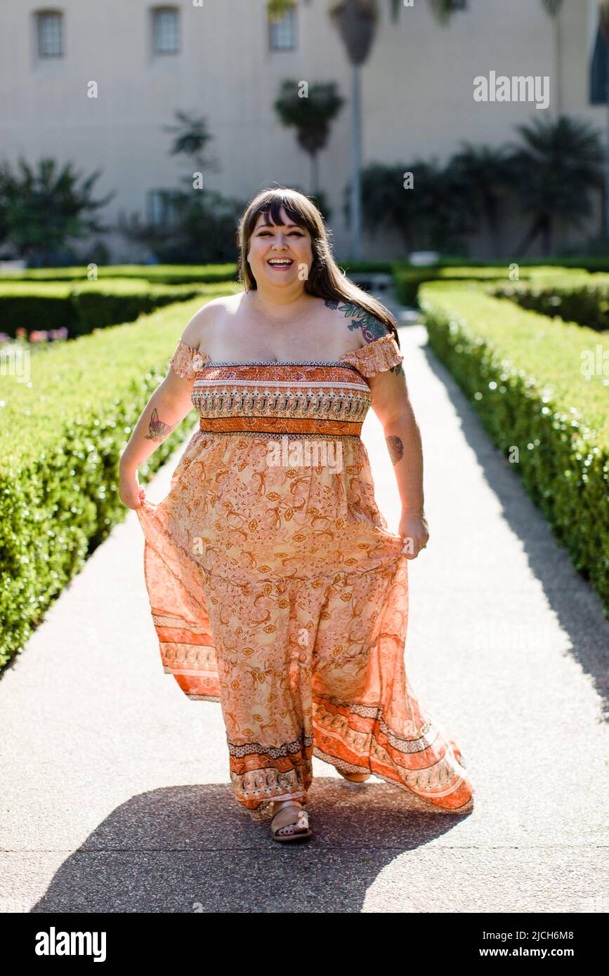 Modello Plus Size con abito lungo arancione a San Diego Foto Stock