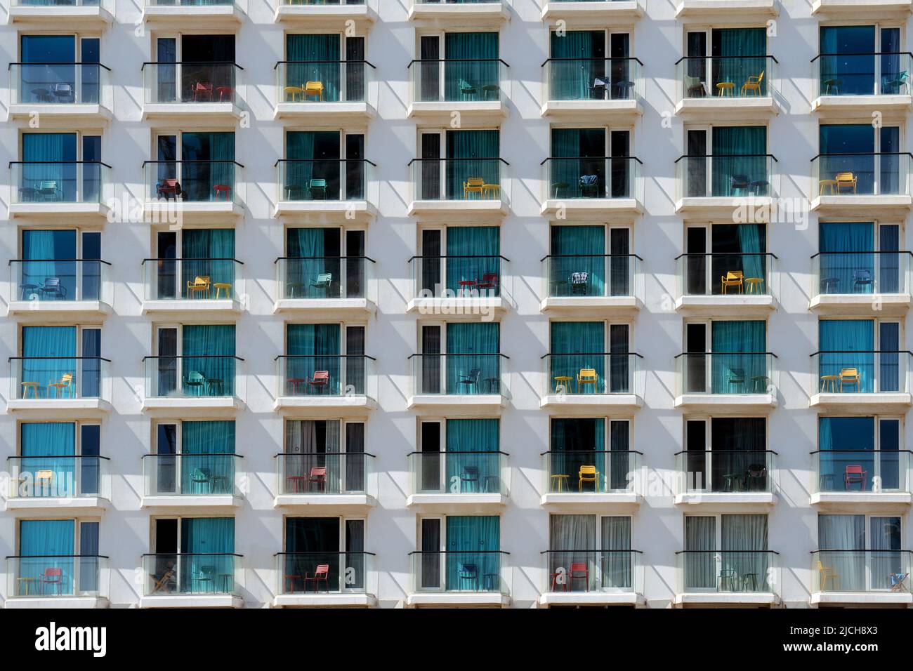 Sfondo con finestre dell'hotel con sedie sui balconi Foto Stock