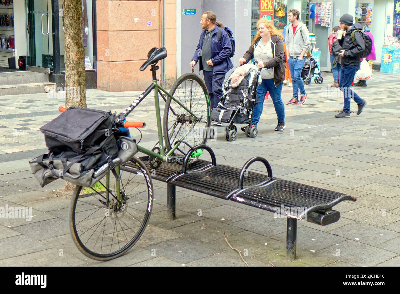 Glasgow, Scozia, Regno Unito giugno 13th 2022. UK Weather: Un approccio creativo alla sicurezza della bicicletta in quanto la bicicletta è bloccata su una panca rubata in posizione seduta. Una giornata calda ha visto la gente del posto e i turisti portarsi in piazza george e nelle strade circostanti della città questo pomeriggio. Credit Gerard Ferry/Alamy Live News Foto Stock