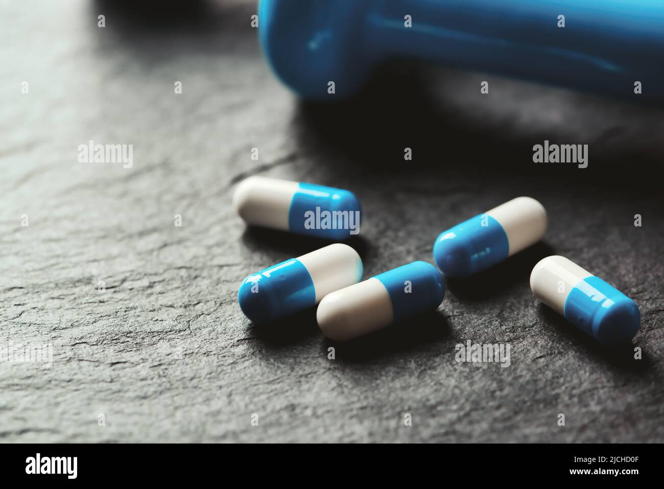Supplementi sportivi (creatina capsule) su sfondo di pietra scura. Primo piano. Spazio di copia. Foto Stock