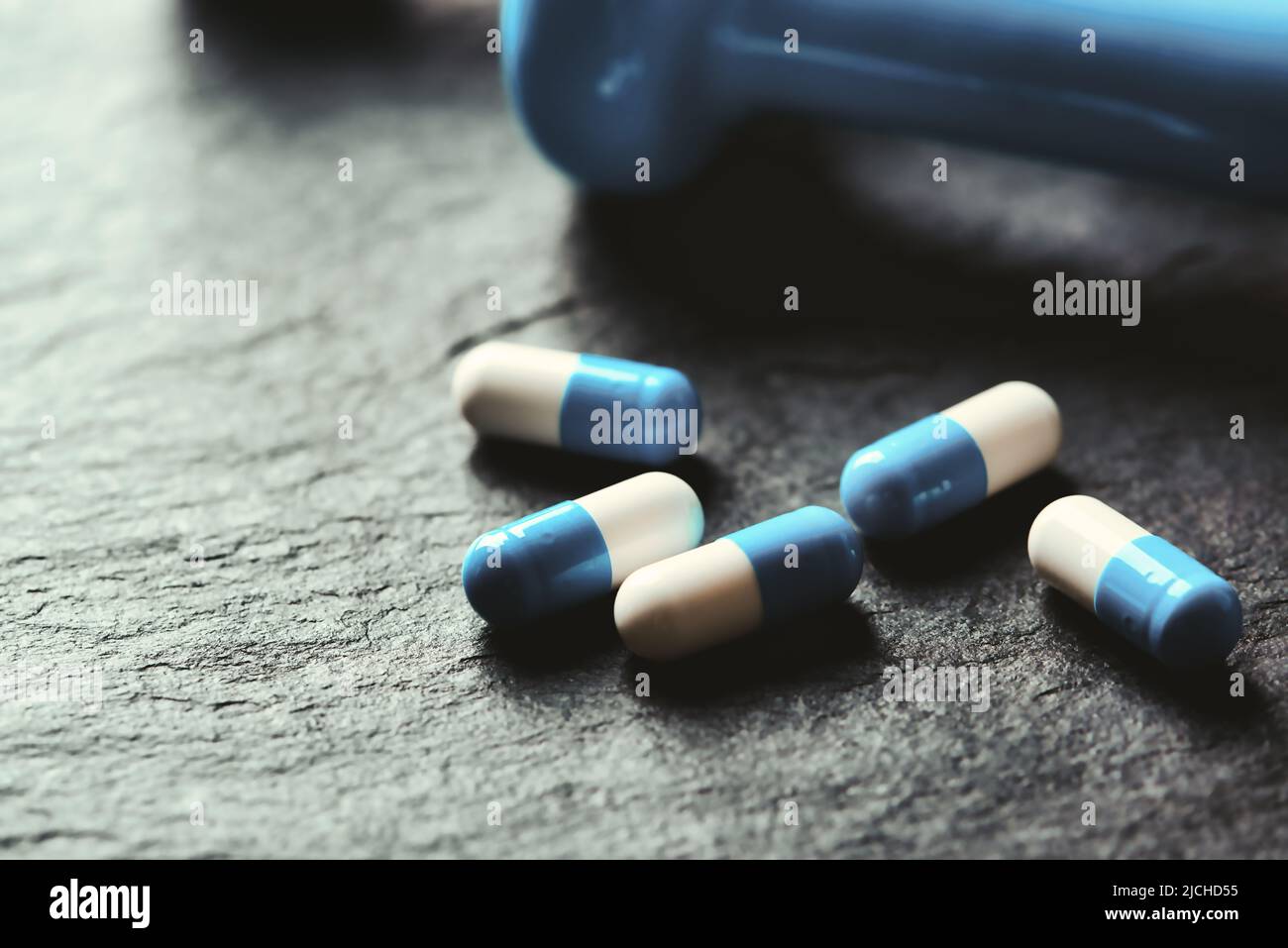 Supplementi sportivi (creatina capsule) su sfondo di pietra scura. Primo piano. Spazio di copia. Foto Stock