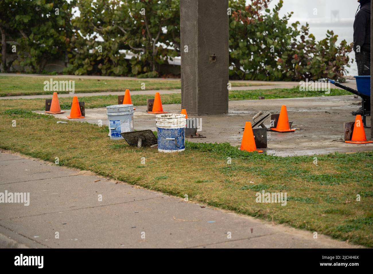 I coni arancioni vicino al marciapiede in un cantiere in un parco pubblico vengono utilizzati per prevenire le lesioni. Foto Stock