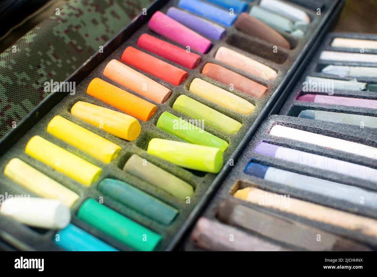 Morbido arcobaleno colorato gesso pastello per disegnare. I pastelli dell'artista multicolore nella scatola. Foto Stock