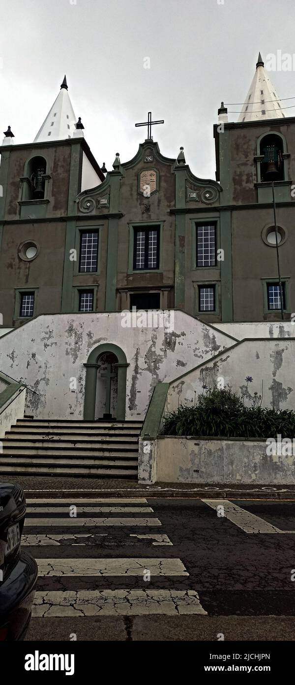 Antica chiesa cattolica sull'isola di Terceira con una facciata verde-grigia e scale bianche Foto Stock