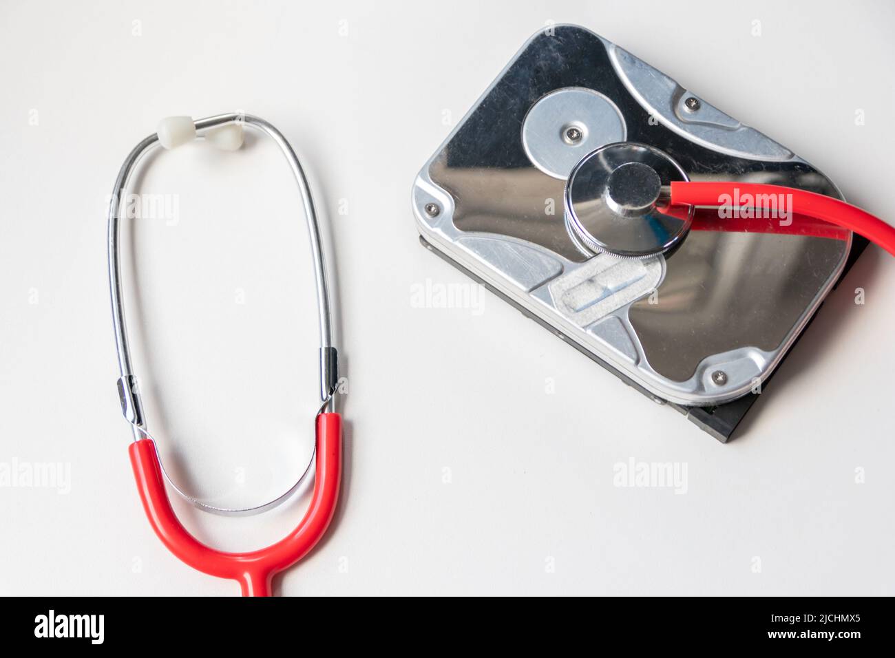 Lo stetoscopio rosso con unità disco rigido interna hdd contiene record di stato e dati paziente sensibili con controllo medico hardware e violazione dei dati di riposo Foto Stock