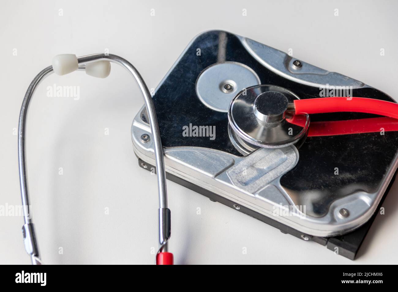 Lo stetoscopio rosso con unità disco rigido interna hdd contiene record di stato e dati paziente sensibili con controllo medico hardware e violazione dei dati di riposo Foto Stock