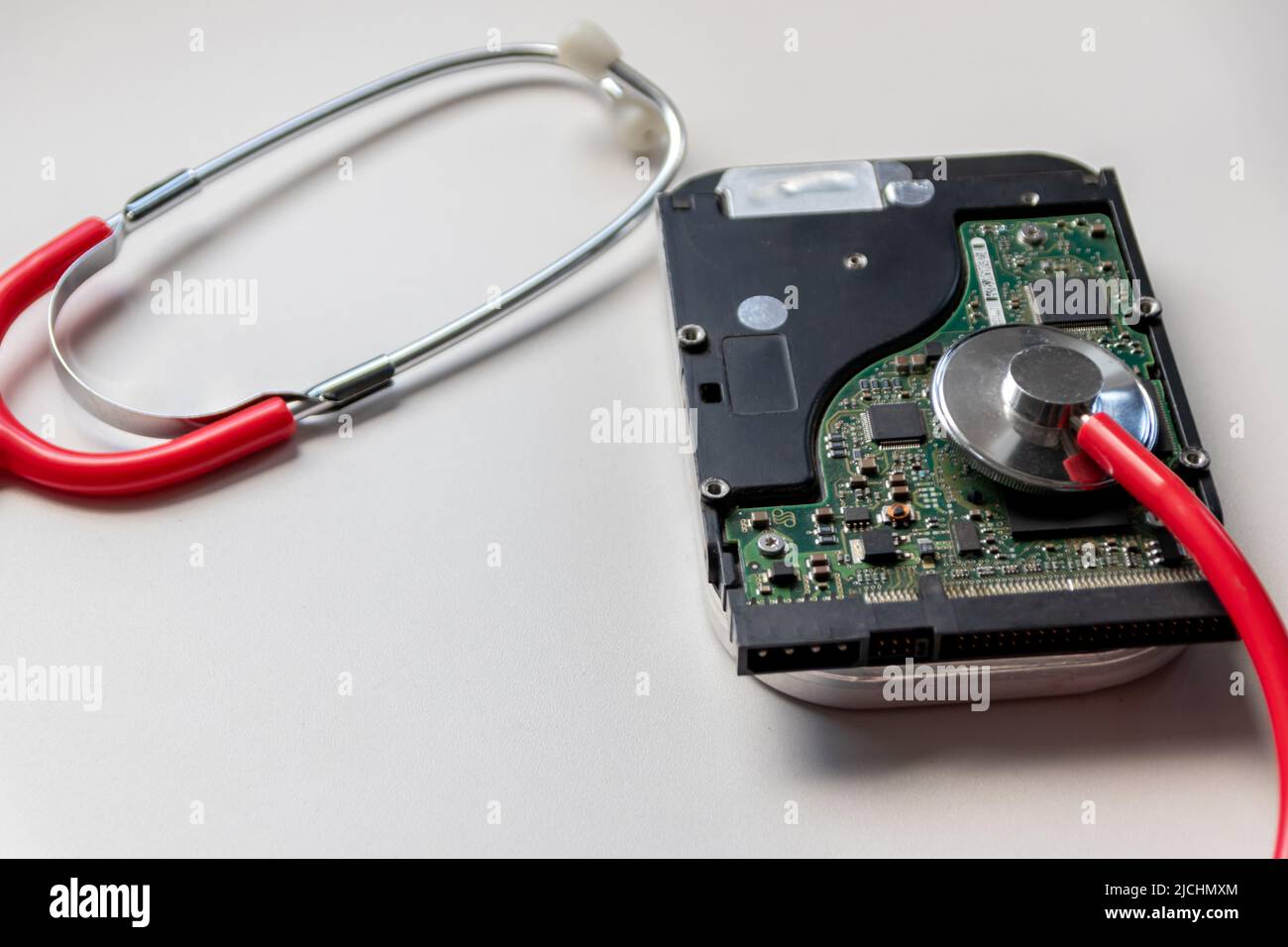 Lo stetoscopio rosso con unità disco rigido interna hdd contiene record di stato e dati paziente sensibili con controllo medico hardware e violazione dei dati di riposo Foto Stock