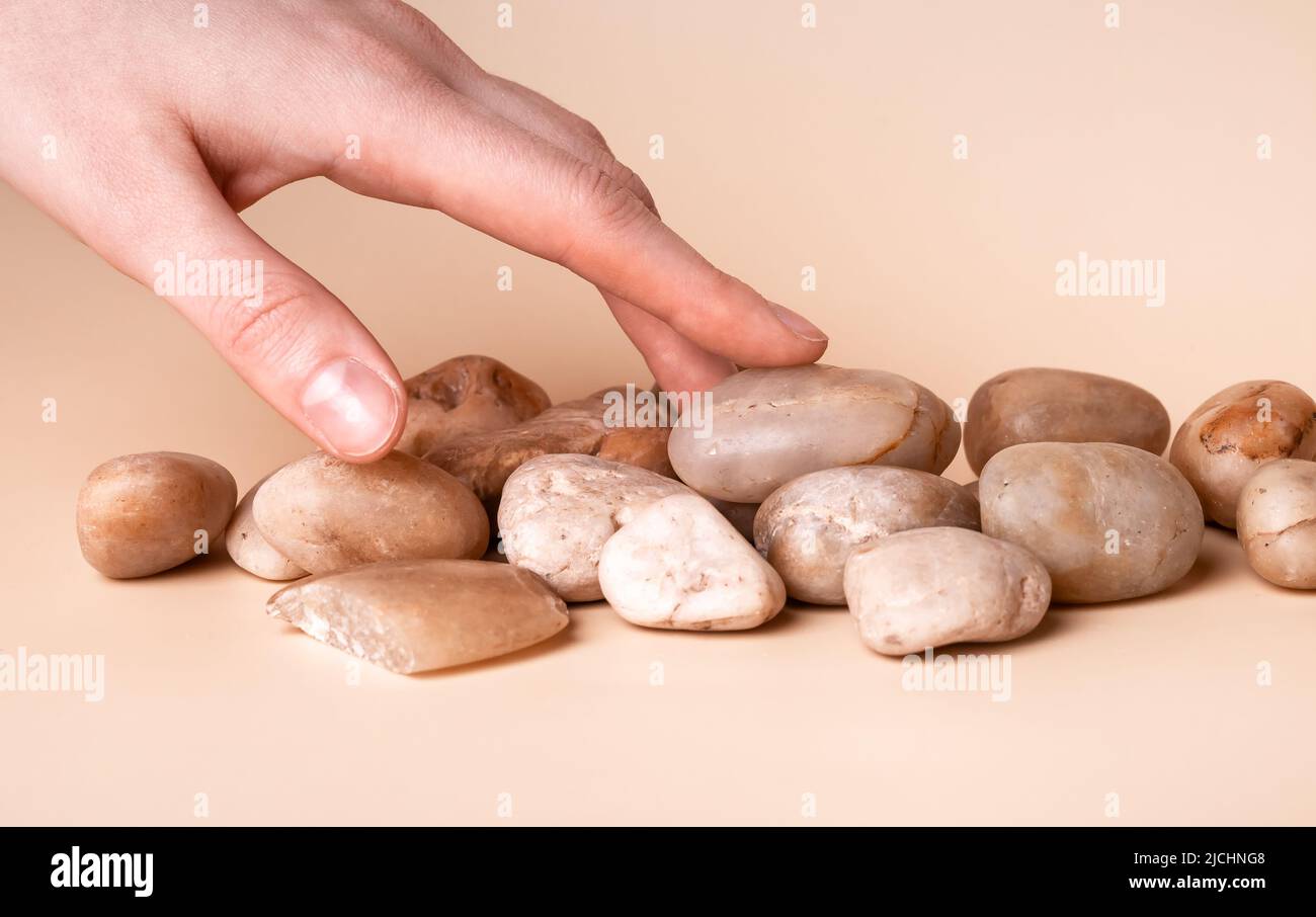 Concetto di sensibilità tattile e sensoriale. Mano che tocca pietre closeup. Foto di alta qualità Foto Stock