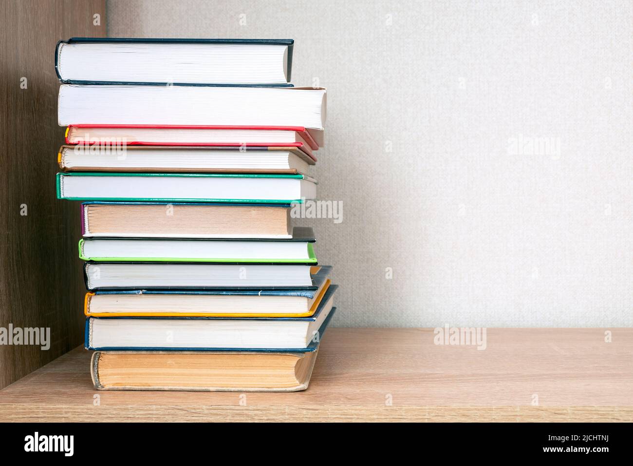 Pila di libri su una libreria, concetto di formazione Foto Stock