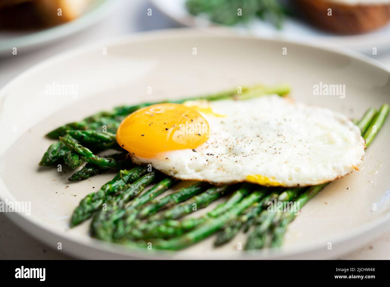 Uova fritte con asparagi verdi. Idee per il pranzo veloce, colazione sana, cibo estivo. Foto Stock