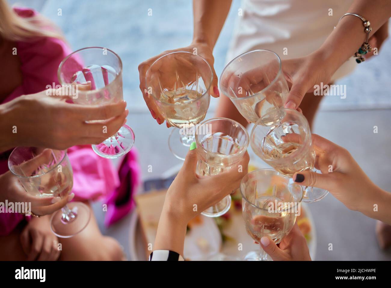 Celebrazione. Persone azienda bicchieri di vino bianco e fare un brindisi Foto Stock